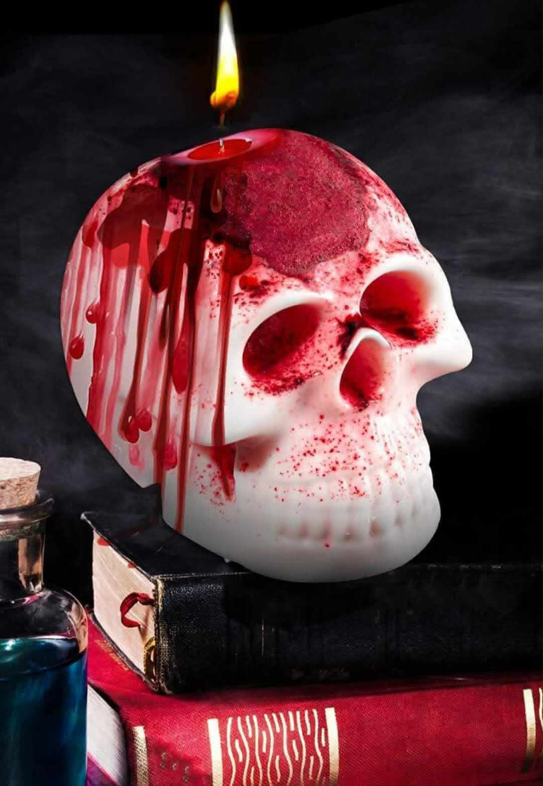A white skull-shaped candle lit against a dark backdrop